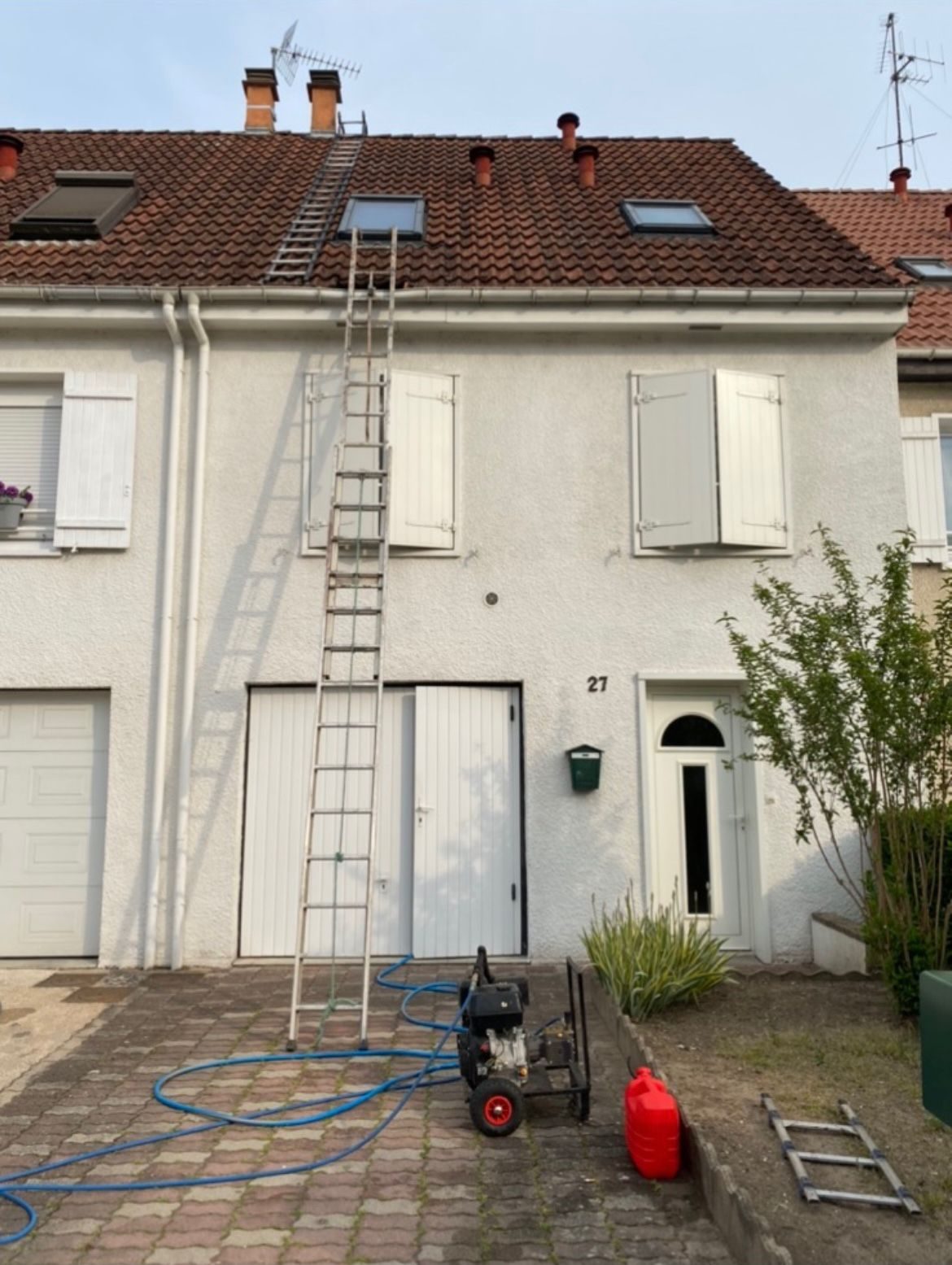 Maison avec fenêtres de toit et échelle posée
